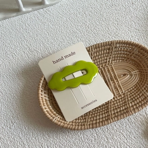 Green wavy cloud-shaped BB hair clip with hollow design on handmade display card