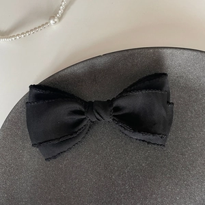 Gros plan d'un nœud papillon en satin noir avec texture fine et perles élégantes