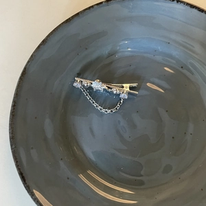 Elegant silver butterfly heart hair clip with zircon and tassel chain on ceramic plate
