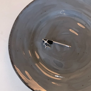 Close-up of a silver punk-style metal hair clip with a star and black rectangle inlay