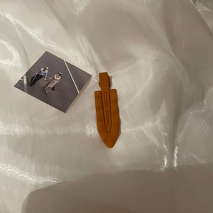 Close-up of matte ginger orange wavy hair clip showing smooth texture and metal base