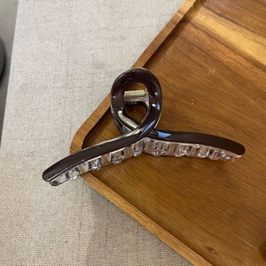 Close-up of a large coffee-colored shark hair claw clip with a glossy resin finish