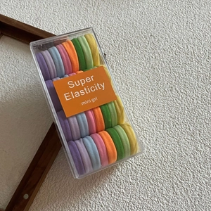 Macro detail of high elasticity candy-colored hair ties set in clear plastic packaging