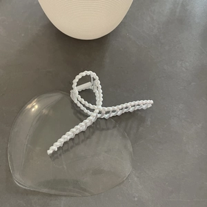 Detailed macro view of large white twist hair claw clip with pearl luster finish