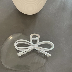 Minimalist white bow-shaped hair claw clip with cross geometric design and matte finish