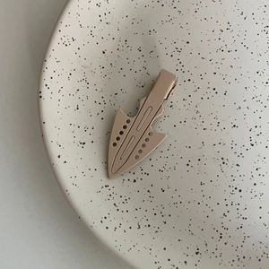 Minimalist matte beige geometric duckbill hair clip on elegant ceramic dish