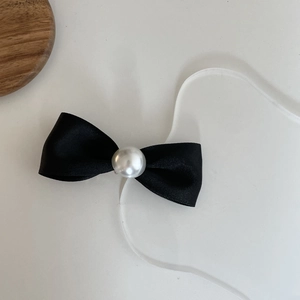 Elegant black satin bow hair clip featuring a glossy white pearl center ornament