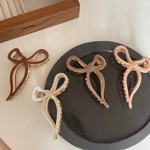 Elegant acetate bow hair claws in various colors with gold metal base for women