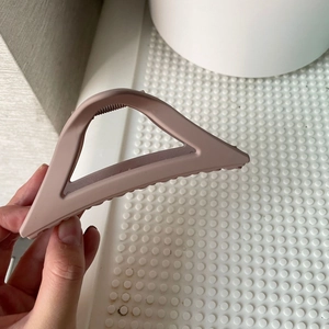 Detail view of large matte triangle hair claw clip in elegant dusty rose color