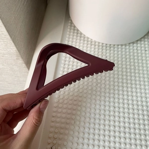 Close-up of a matte dark red triangle hair claw clip for elegant bun styling and hairstyles