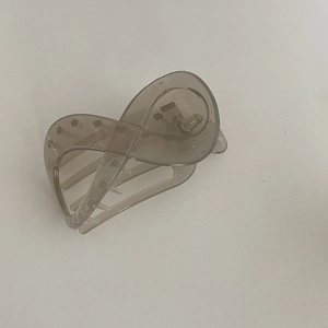 Détail de la pince à cheveux gris foncé translucide avec dents antidérapantes et texture