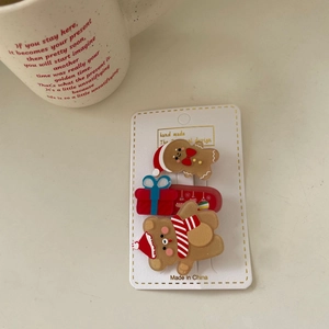 Detailed view of Christmas themed hair clips with gingerbread man and bear on card