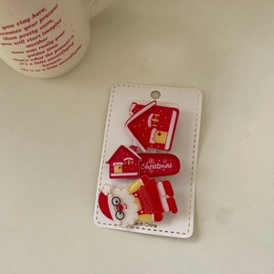 Close-up of Santa Claus and red house hair clips set with festive holiday design