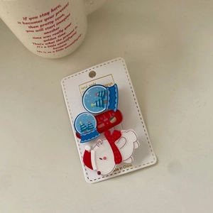 Detail view of festive Christmas hair clips set with polar bear and crystal ball motifs
