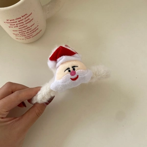Close-up of a plush white hair clip featuring a 3D Santa Claus head for Christmas