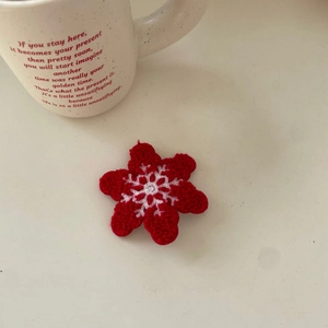 Detail of red crochet snowflake hair clip with handmade yarn texture for Christmas