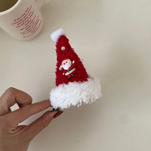 Detail of plush Christmas hat hair clip with Santa Claus figurine and pearl accents