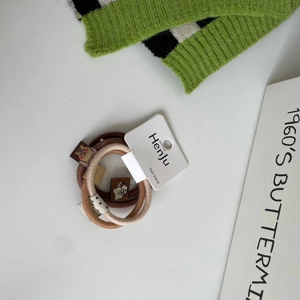 Detailed close-up of soft knit hair ties with cute bear tag on a display card