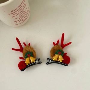 Detail of Christmas reindeer antler hair clips with red flocking and golden bells