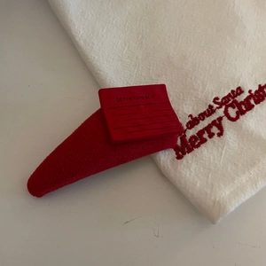Detailansicht einer roten stoffumwickelten Haarspange mit quadratischem Zierelement
