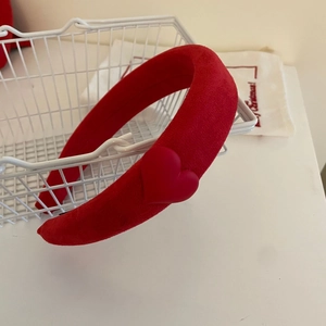 Detail eines roten Haarreifens mit Samtherz in einem weihnachtlichen Geschenkkorb