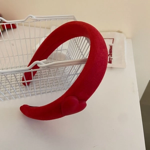 Detail eines roten gepolsterten Stirnbands mit 3D-Herz für festliches Styling