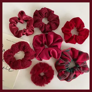 Set of seven red scrunchies in velvet, satin, and wool fabrics for elegant hair styling
