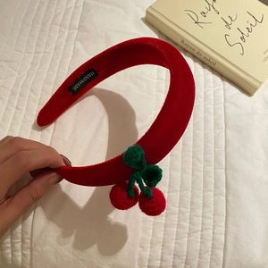 Detail of red velvet headband with handmade crochet cherry decor and handmade label