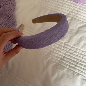 Détail du bandeau en tissu violet avec motif texturé et doublure antidérapante beige