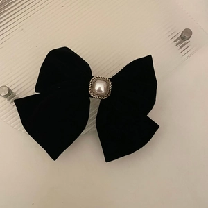 Elegant black velvet bow hair clip with a centered vintage pearl in a gold frame