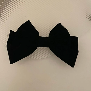 Detail view of large black velvet bow hair clip with elegant multi-layer fabric structure