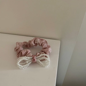 Primer plano de coletero rosa con un elegante adorno de lazo de perlas blancas falsas
