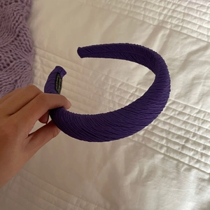 Vue détaillée du serre-tête plissé violet foncé avec rembourrage épais et étiquette interne
