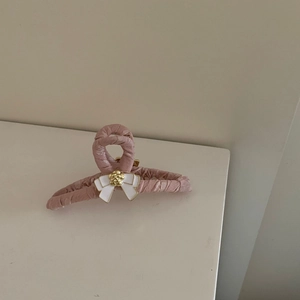 Pinza para el pelo en tela rosa con lazo blanco y detalle de flor dorada para peinados