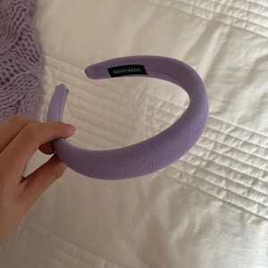 Détail d'un serre-tête tricoté violet rembourré avec tissu doux et étiquette faite main