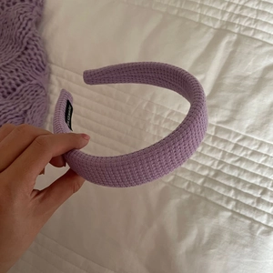 Détail d'un serre-tête en tissu gaufré lavande avec texture tissée et étiquette artisanale