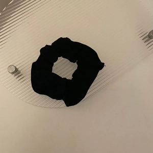 Detail view of the black velvet scrunchie texture and elastic fabric ruffles