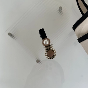 Fermaglio stile francese con perla bianca, fiocco dorato e strass su base nera