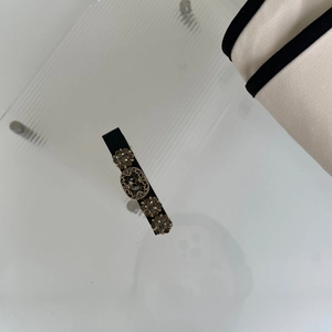 Dettaglio di elegante fermaglio nero con strass vintage e decorazioni floreali in cristallo