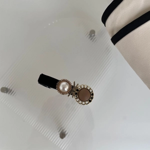 Dettaglio della clip per capelli con perle e strass stile francese e bordo in pizzo dorato
