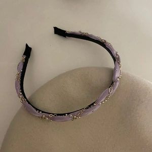 Serre-tête élégant en tissu lavande avec chaînes dorées, perles blanches et un nœud chic