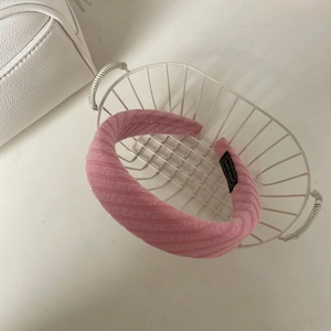 Serre-tête en tricot à rayures rose poudré dans un panier décoratif en fil blanc