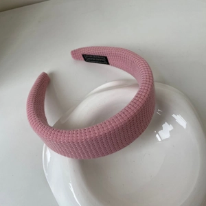 Vue détaillée du serre-tête rose à texture gaufrée avec étiquette faite à la main