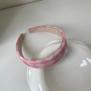 Détail d'un serre-tête à carreaux roses avec doublure antidérapante sur plateau