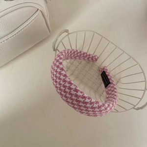 Vue détaillée du serre-tête rose à motif pied-de-poule avec étiquette faite main