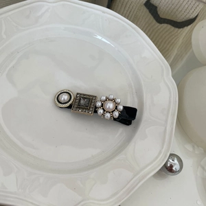 Detailed macro view of French style velvet hair clip with pearl and crystal embellishments