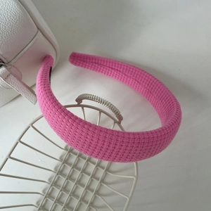 Détail de la texture tricotée rose et de la doublure antidérapante noire du serre-tête