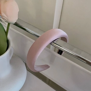 Pink satin padded headband with sponge thickness shown on a stylish metal stand
