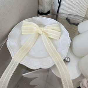 Elegant French style cream bow hair clip with lace texture and long flowing ribbons
