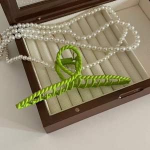Matte grasgrüne Haarklammer im gedrehten Design in einer luxuriösen Samtbox